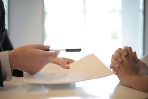 Close de uma assinatura de contrato com entrega de documentos. Interação profissional de negócios.